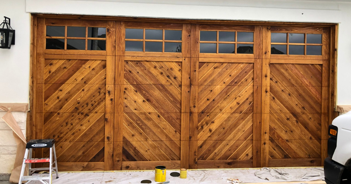 Wooden garage doors with diagonal panels and top windows.